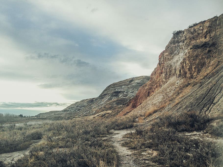 rocky mountain under gray clouds, brown, cyan, plants, rocks HD wallpaper