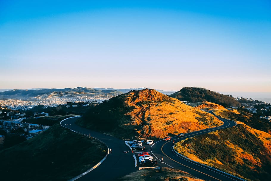 concrete road under blue sky, aerial photo of hill between road HD wallpaper