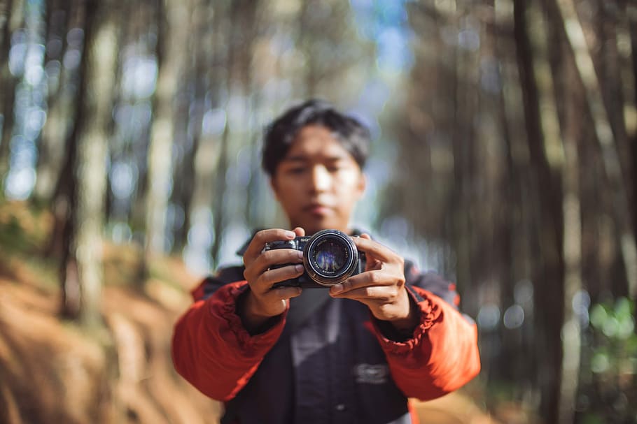 man holding camera taking a photo, selective focus photography of man holding camera HD wallpaper