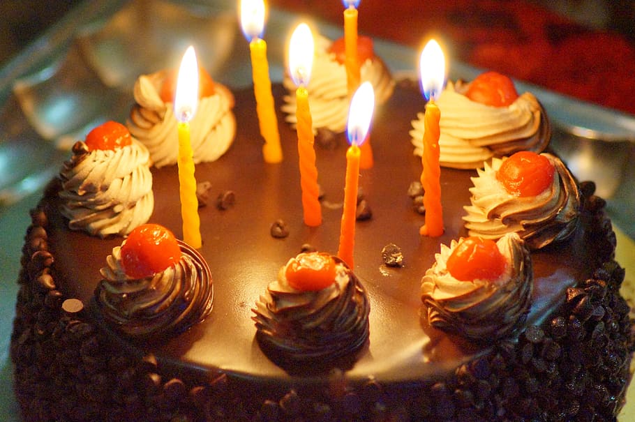 close up photo of round chocolate cake with candles, birthday
