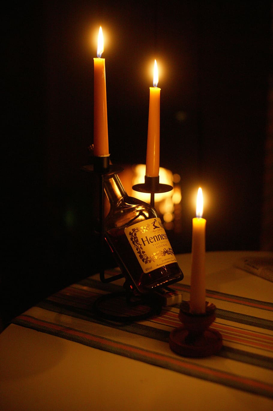 close-up photography of black and white label bottle beside pillar candles