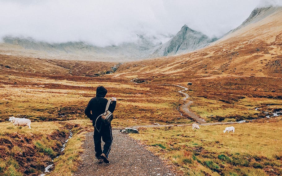 man walking on road towards mountain, person carrying backpack standing on pathway HD wallpaper