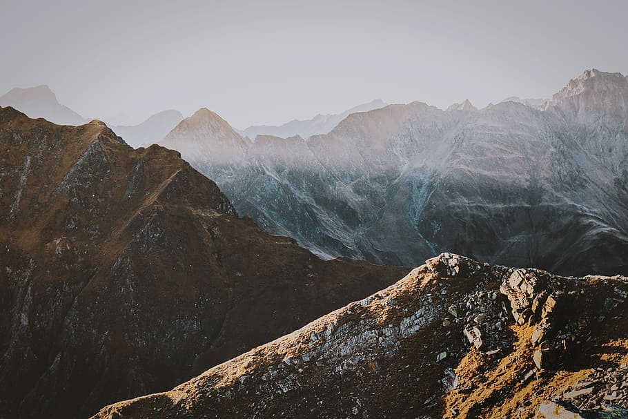 brown mountains covered with fog, photo of mountain peak under white sky HD wallpaper