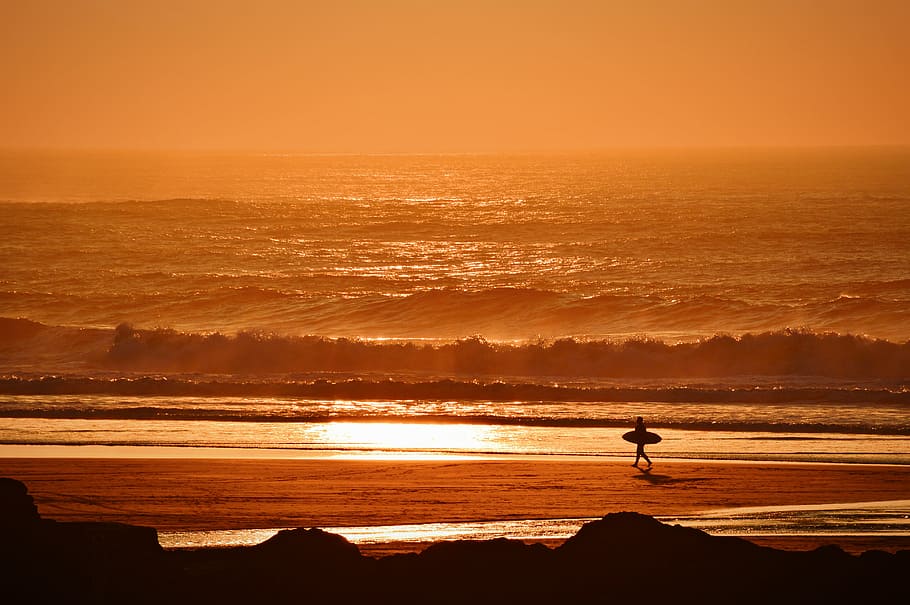 person holding surfboard walking on seashore during golden hour, person holding surfboard on seashore during golden hour HD wallpaper