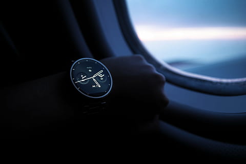 person wears black and grey smartwatch while riding airplane HD wallpaper