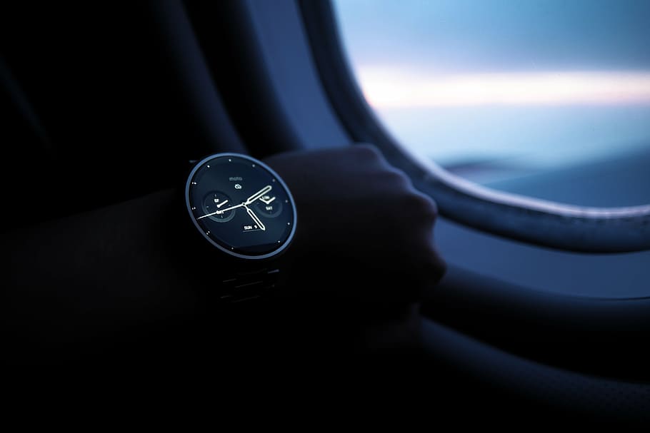 person wears black and grey smartwatch while riding airplane HD wallpaper