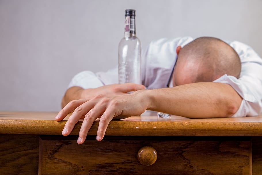 man leaning on desk while holding bottle, alcohol, hangover HD wallpaper