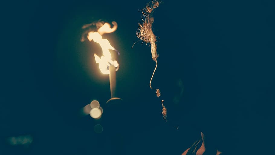 man standing in front of candle, man standing near lighted torch outdoors HD wallpaper