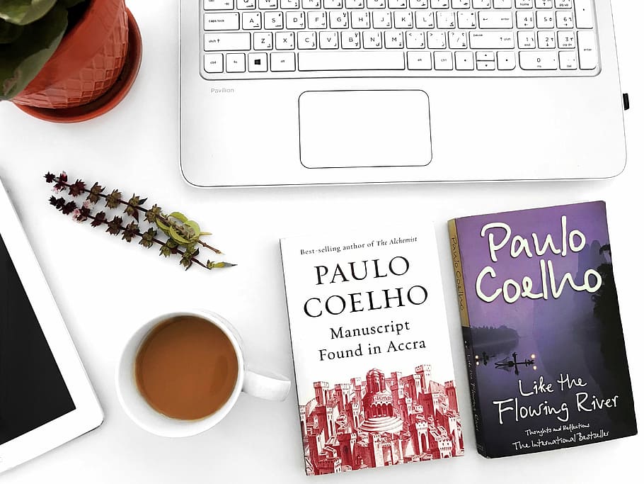 two Paulo Coelho books on table, two Paulo Coelho books on table beside mug filled with coffee HD wallpaper