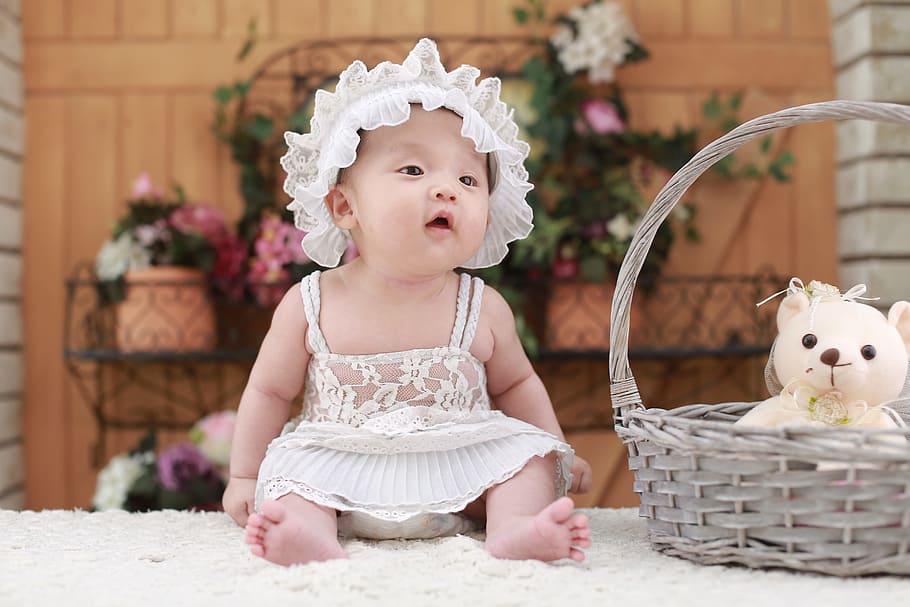 baby in white dress and head band beside wicker brown basket on white fur surface, HD wallpaper