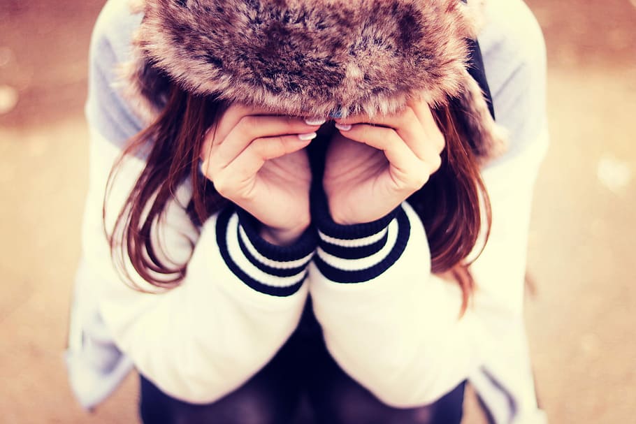 woman in black and white letterman's jacket vowing with hands on eyes during day time HD wallpaper