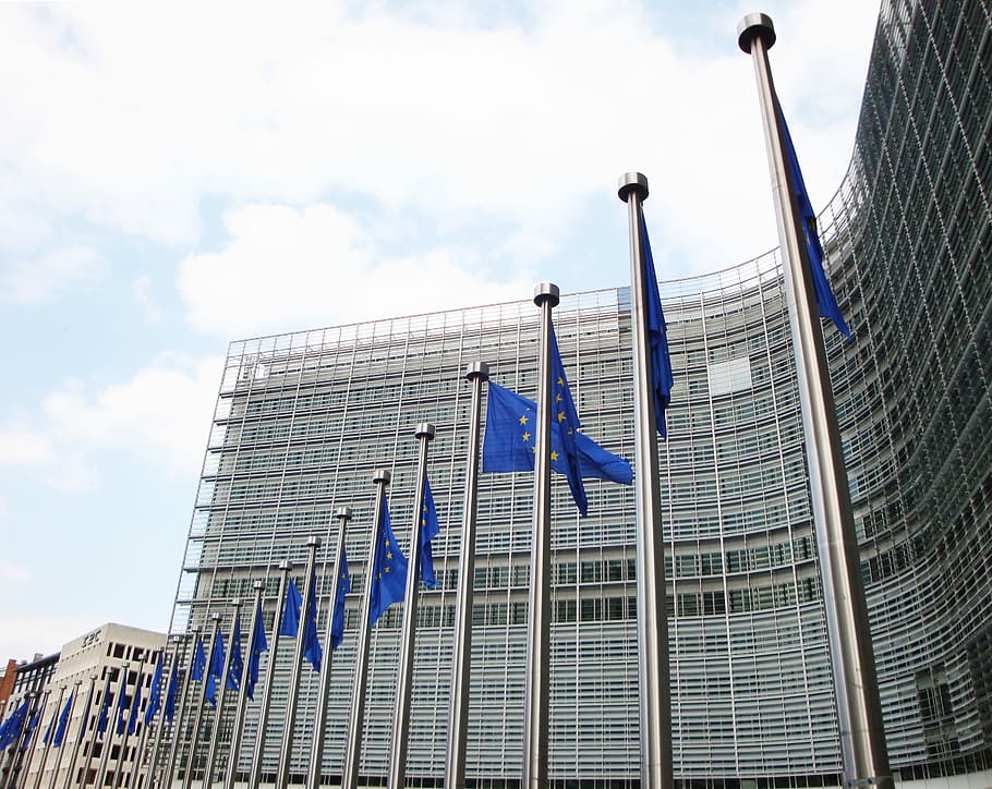 flag formation in stainless steel pole during daytime, eu, european commission