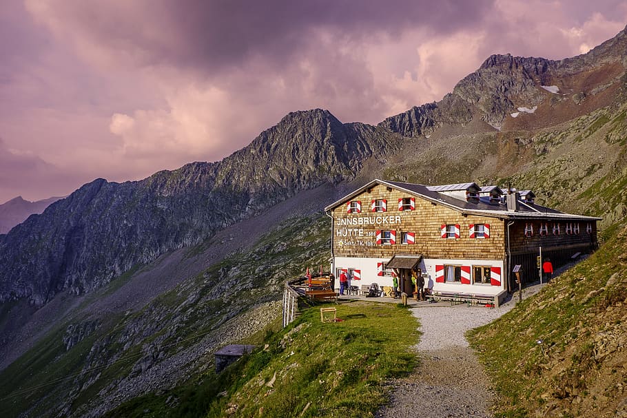 photo of brown house on cliff, brown concrete structure beside mountain cliff HD wallpaper