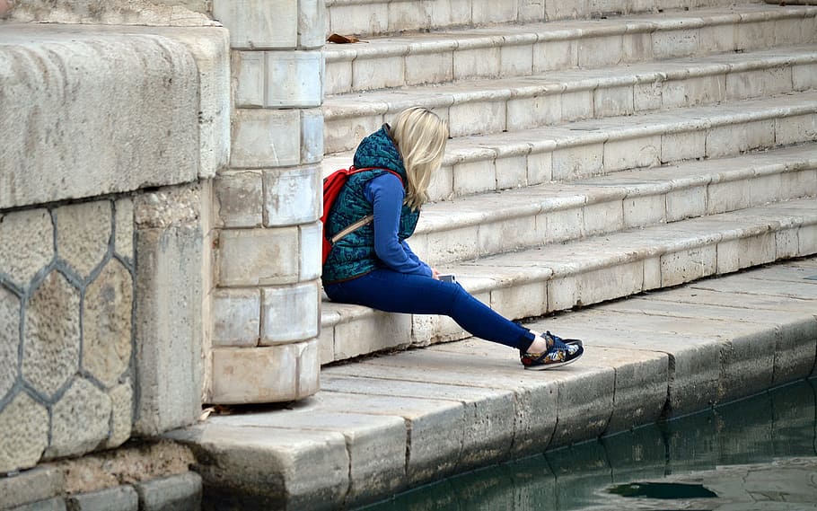 blonde haired woman in blue and green hoodie and blue pants, loneliness