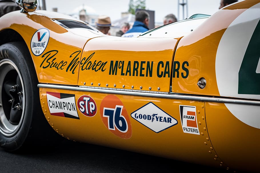 closeup photography of orange McLaren car, yellow racing car with stickers HD wallpaper