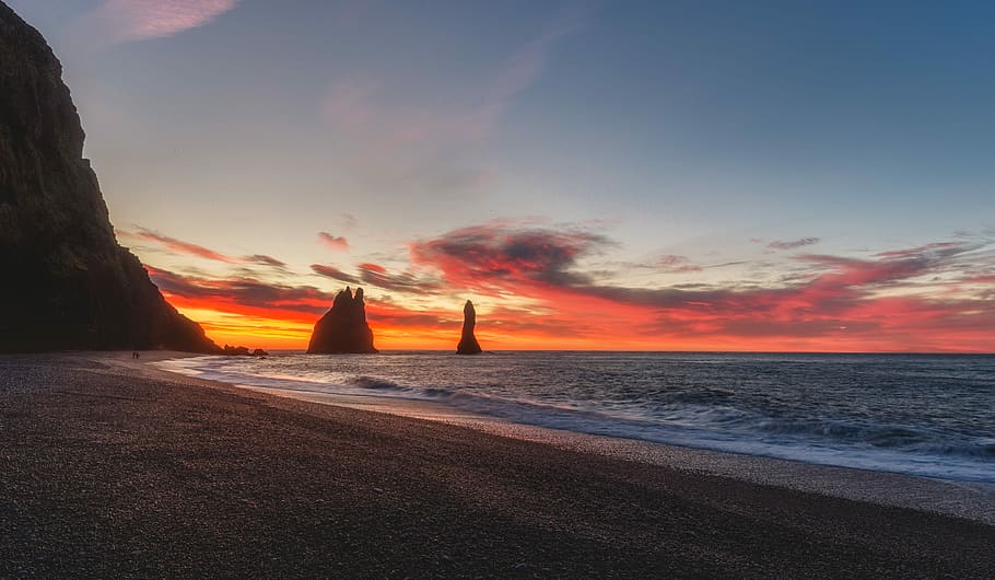 shore near rock formation at golden hour, orange sunset at beach shore HD wallpaper