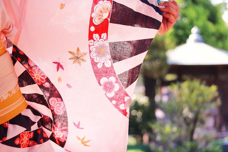 selective focus photography of a person holding red, black, and white floral textile HD wallpaper