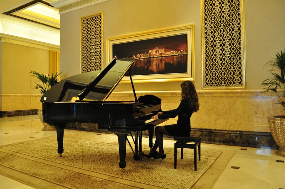woman in black dress playing piano on room, emirates palace hotel