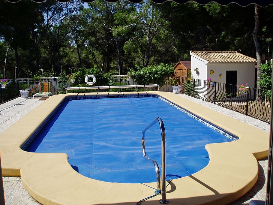 above land swimming pool enclosed by black metal gate, villa