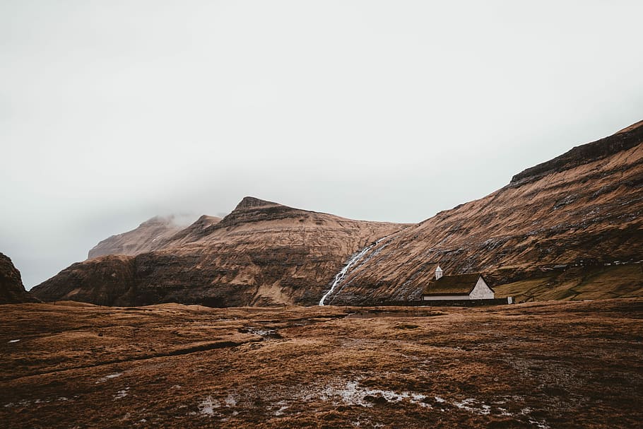 brown and white concrete house on brown mountain, photography of brown house beside brown mountain during daytime HD wallpaper