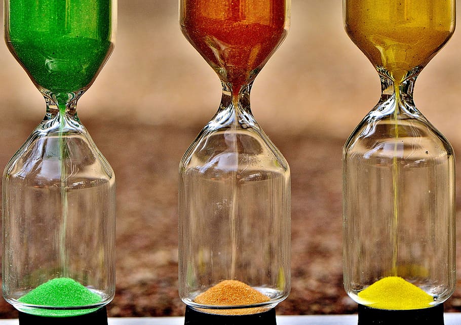 shallow focus photography of three assorted-color hour glasses HD wallpaper