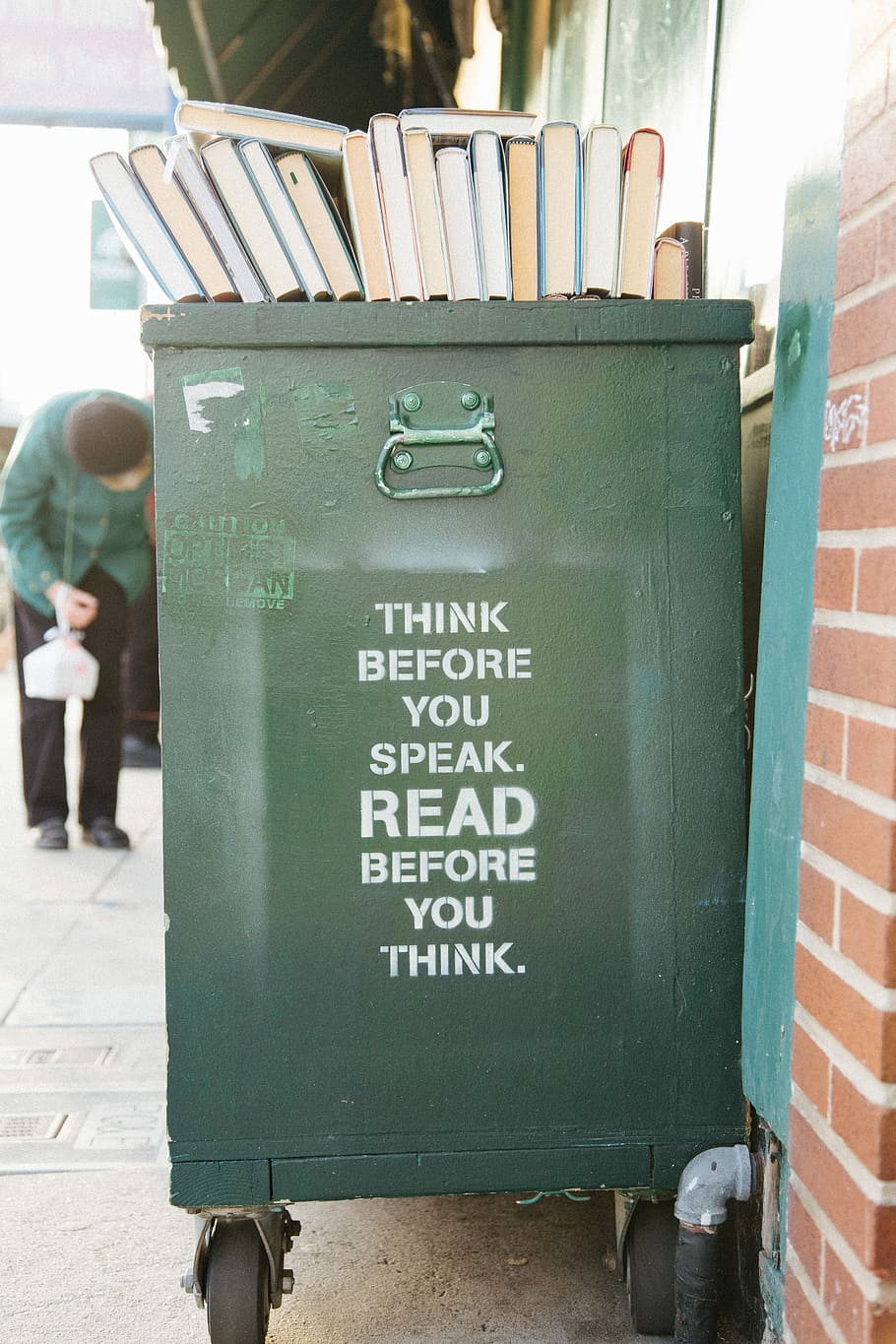 books over green trolley bin, green wooden trash bin, crate, library
