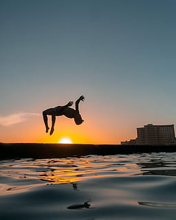 closeup photo of man performing back flip, man back lift at body of water HD wallpaper