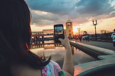 Woman Holding Smartphone Capturing Sunset, architecture, blur HD wallpaper