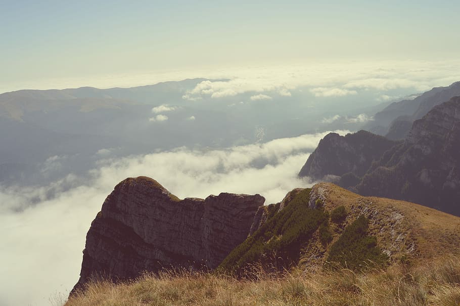 edge of the mountain, green grass field on peak of mountain during daytime HD wallpaper