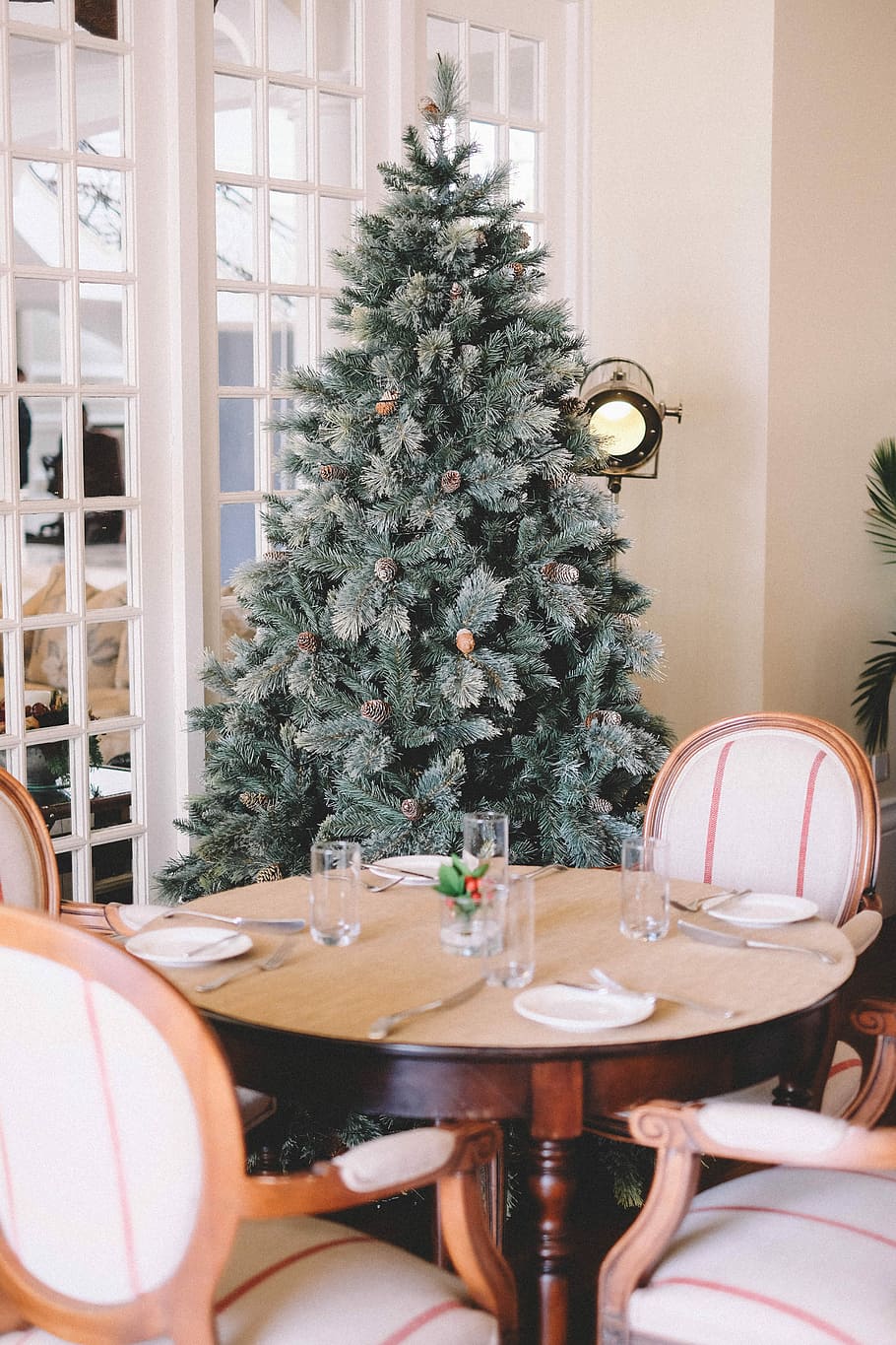 pre-lit tree behind dining set, brown wooden 5-piece dining set in front of Christmas tree HD wallpaper