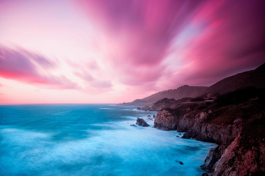 body of water near brown rock plateau, time lapse photography of mountain cliff near body of water HD wallpaper
