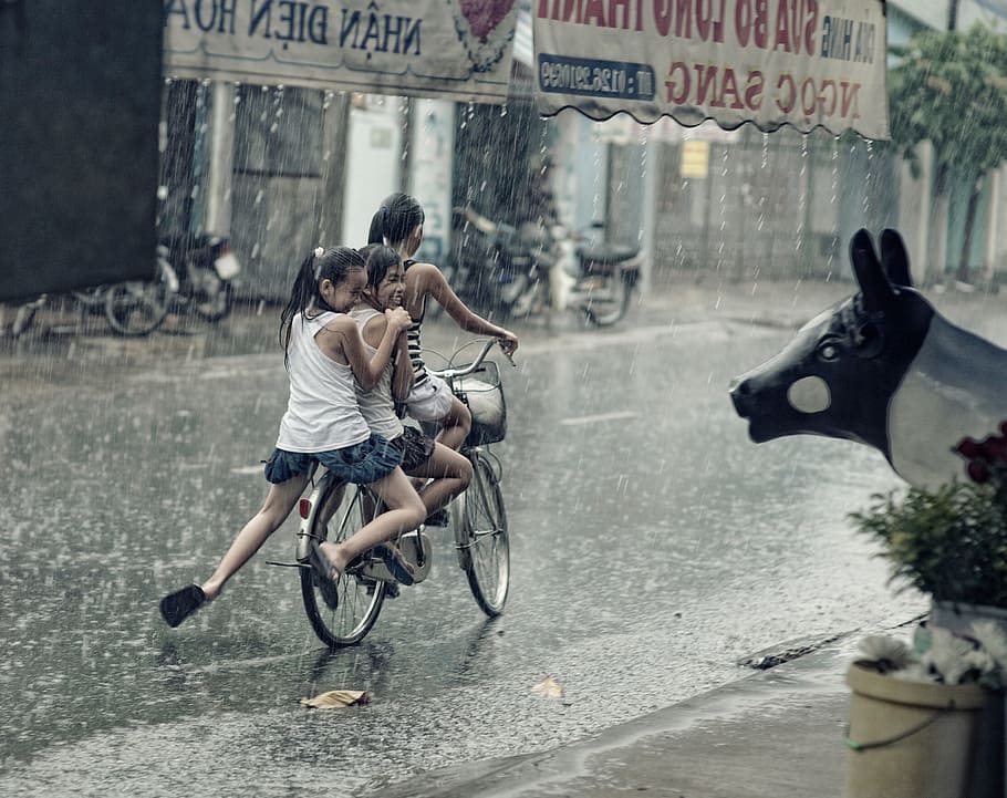 three person riding on bicycle while raining, children, happy