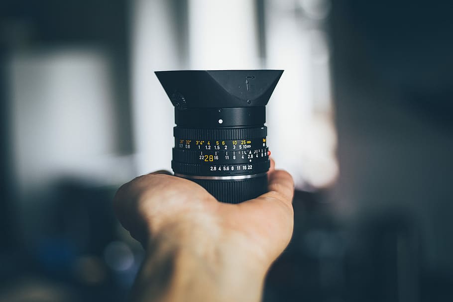 person holding black DSLR camera lens, person holding black telephoto lens HD wallpaper
