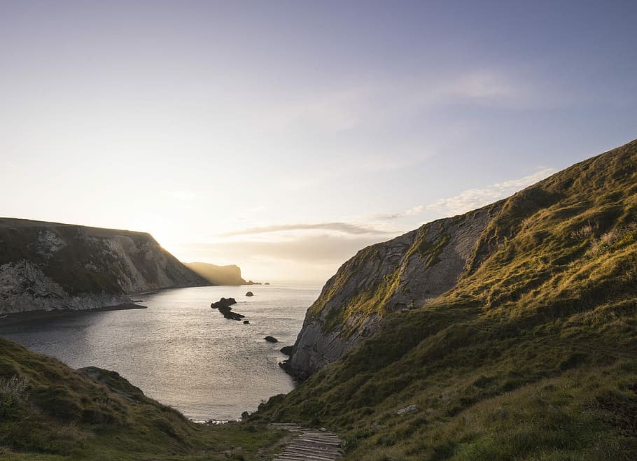 landscape photography of cliff near body of water, aerial photography of ocean and mountain during daytime HD wallpaper
