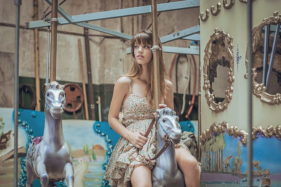 woman in gray floral dress riding carousel, woman in brown spaghetti strap dress riding carousel HD wallpaper