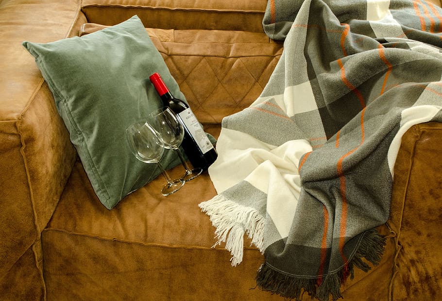 liquor bottle and two red wine glasses on sofa, Couch, Blanket HD wallpaper