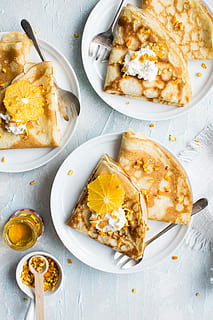 flat-lay photography of pancake with icing, baked roti breads on white ceramic plates HD wallpaper