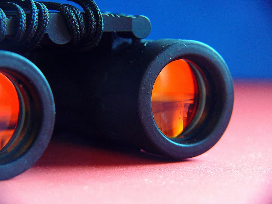 selective focus photography of black and orange binoculars on pink surface HD wallpaper