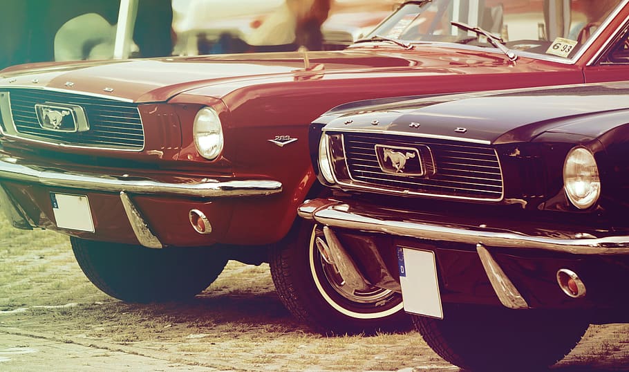 closeup photography of two red and black Ford Mustang Grande during daytime HD wallpaper