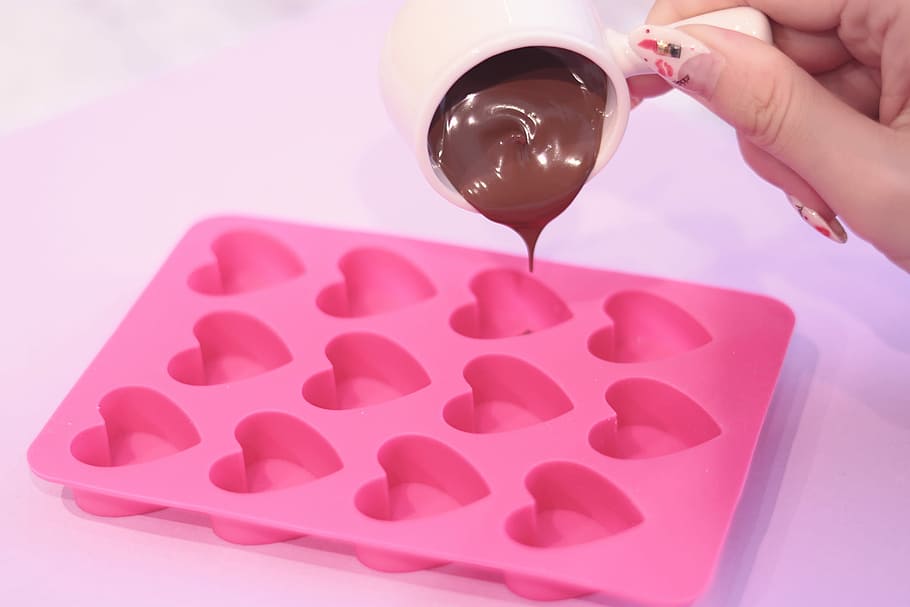 person pouring chocolate in pink heart shape molding tray, red, HD wallpaper