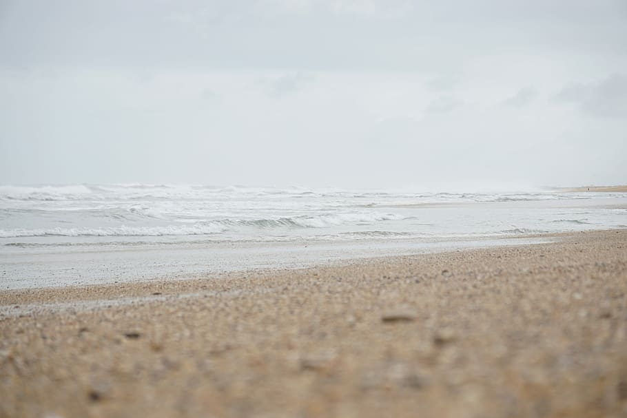body of water across sea shore, low angle photography of shore HD wallpaper