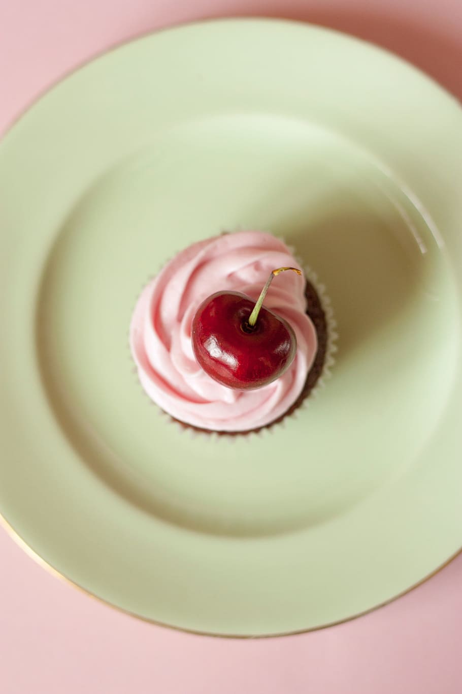 pink cream cupcake with cherry on top on white ceramic plate HD wallpaper