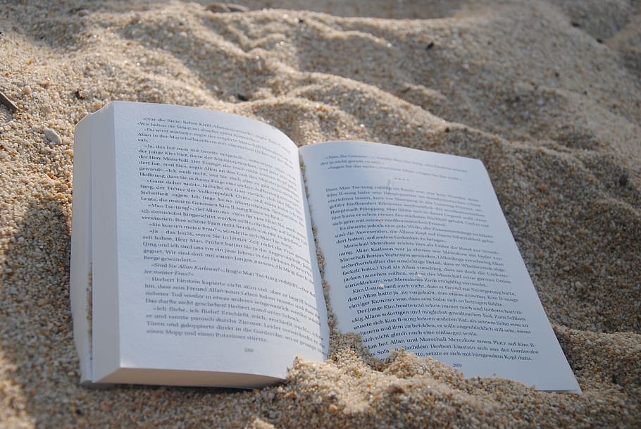 opened book on brown sand, read, literature, pages, book pages
