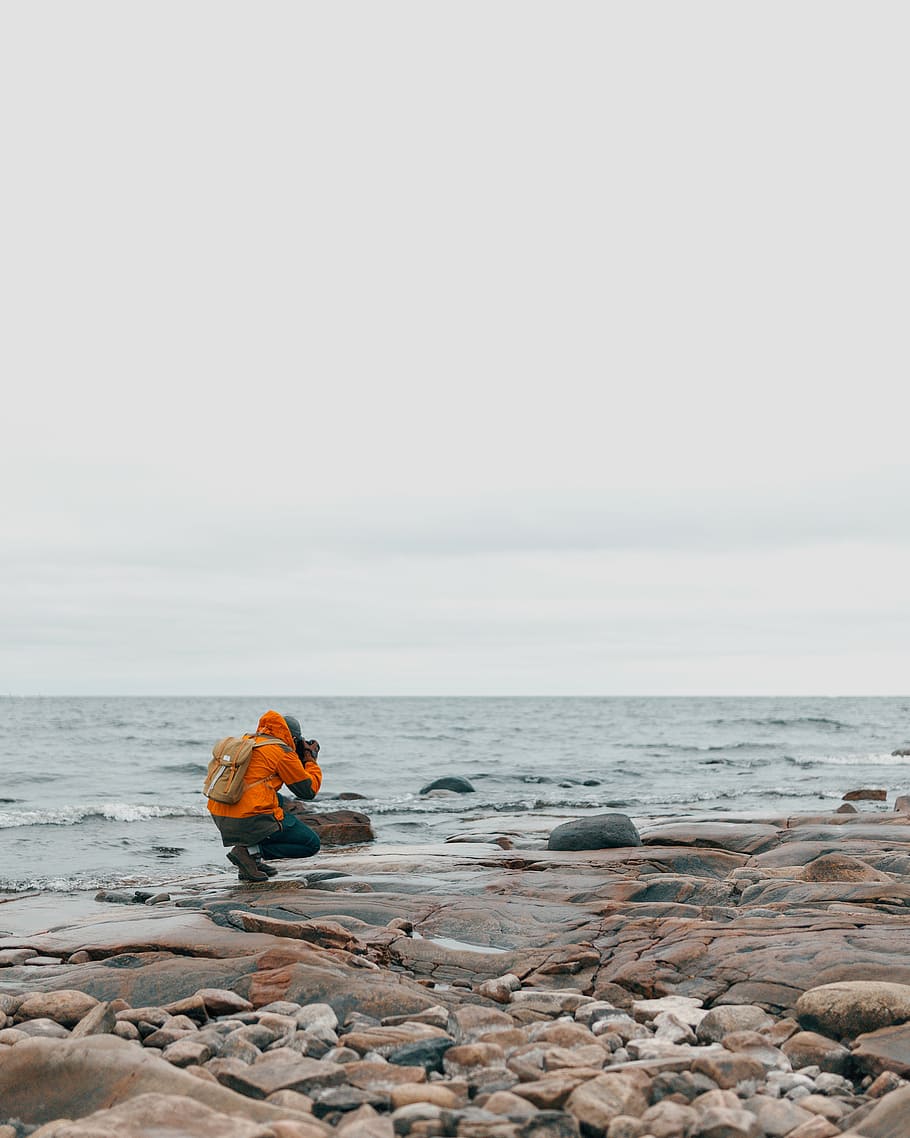 person sitting near body of water while taking a photo, clear HD wallpaper