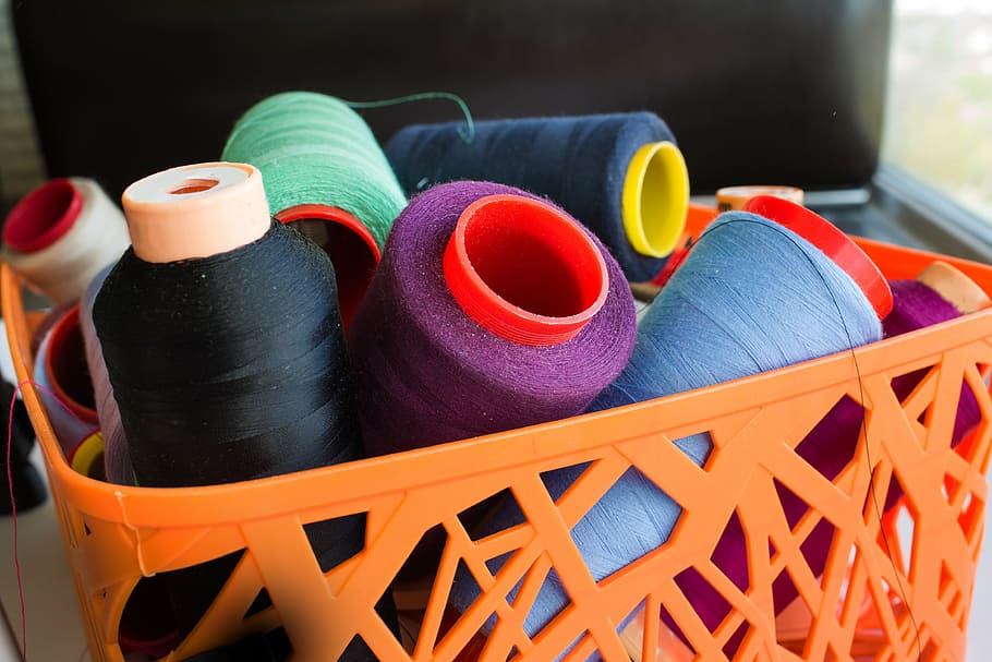 assorted thread rolls on basket, yarn, needlework, background