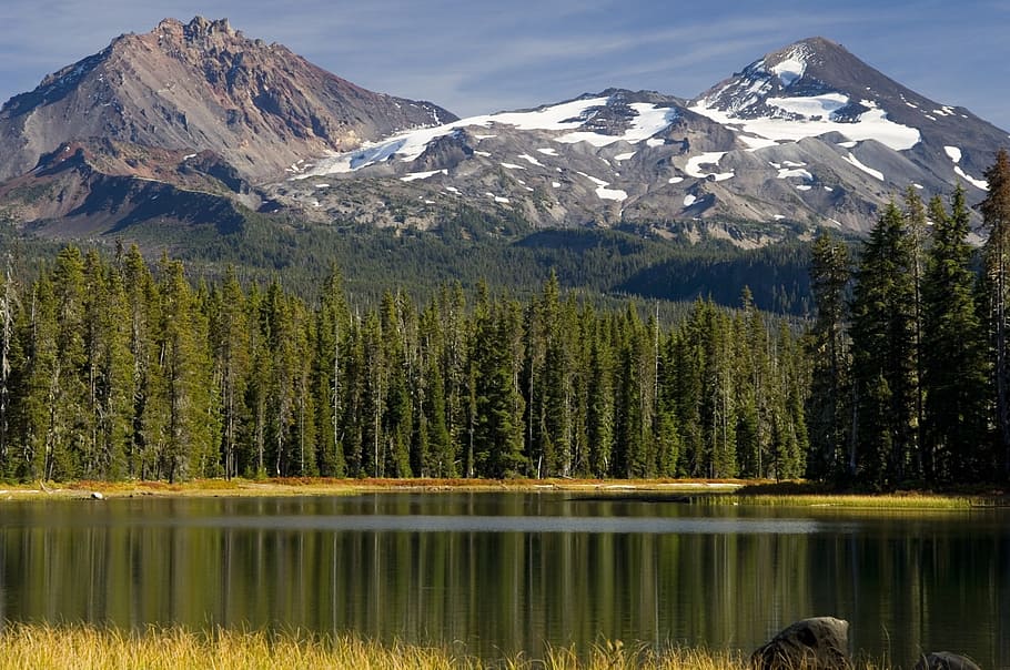 lake surrounded by evergreen trees near snowy mountain during daytime HD wallpaper