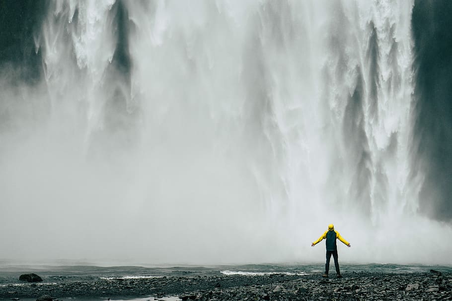 man standing in front of waterfalls at daytime, man standing in front of waterfalls HD wallpaper