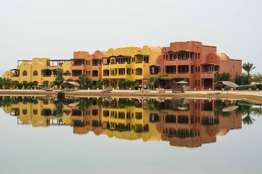reflection of buildings in water, concrete buildings near body of water HD wallpaper