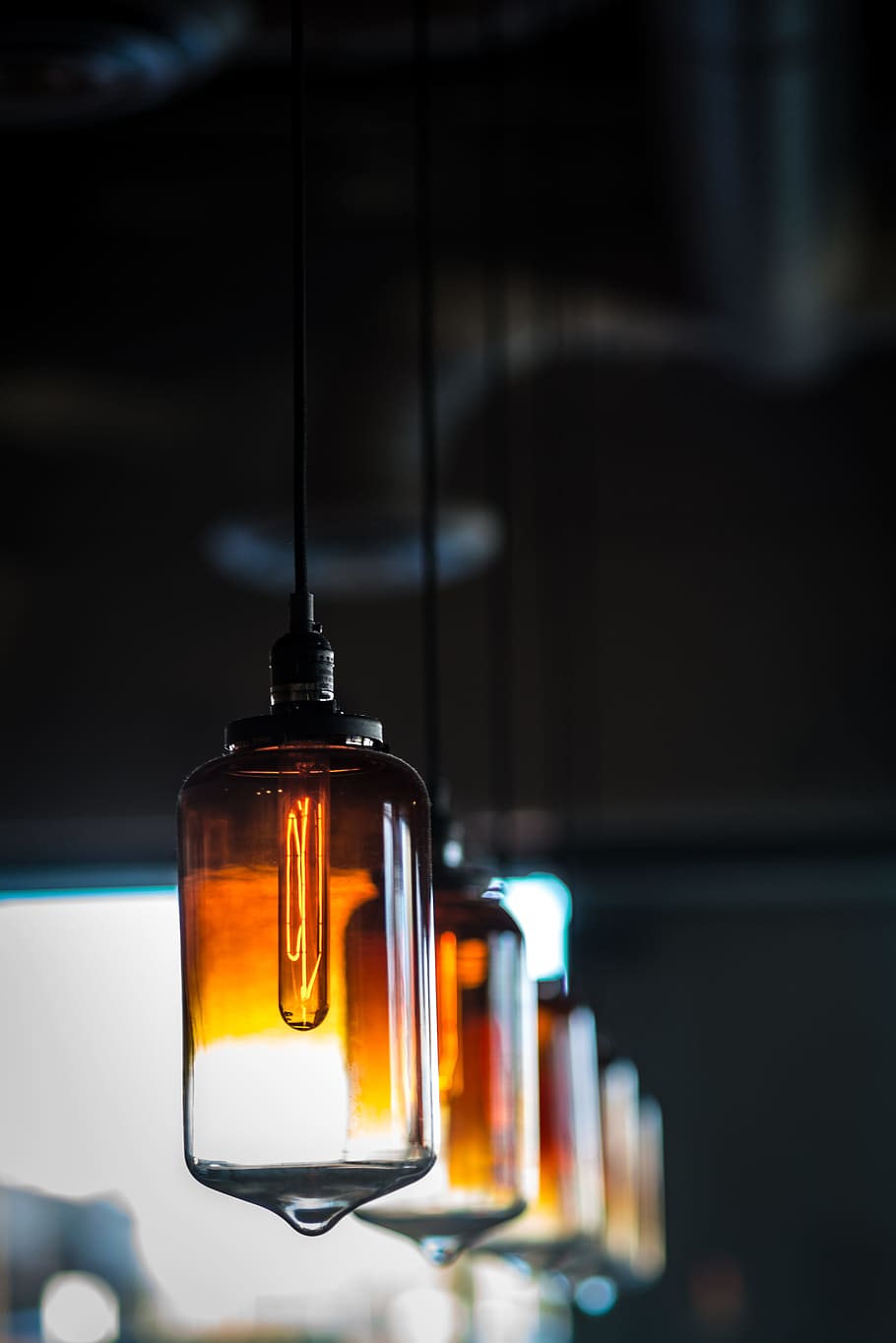 photo of white amber glass lamps, selective focus photography of hanged amber glass lamps