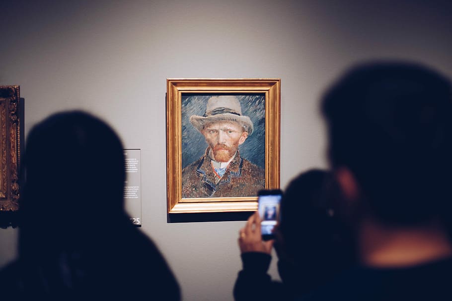 person taking picture of man wearing brown hat painting, people takes photo of man painting inside room HD wallpaper